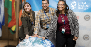 Three people standing around a globe with one person holding it.